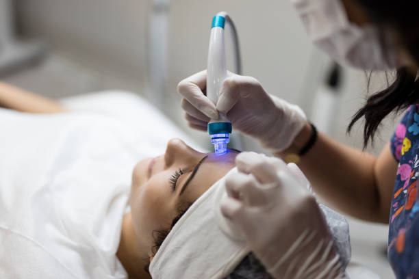Cosmetologist making mesotherapy injection with dermapen on face
